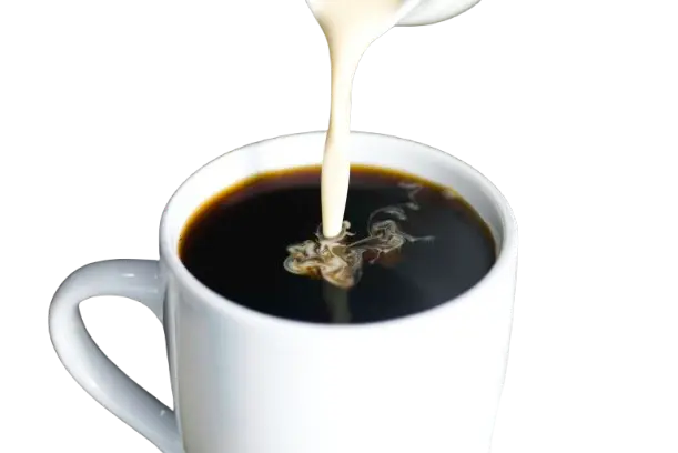 Milk being poured into black coffee in white cup